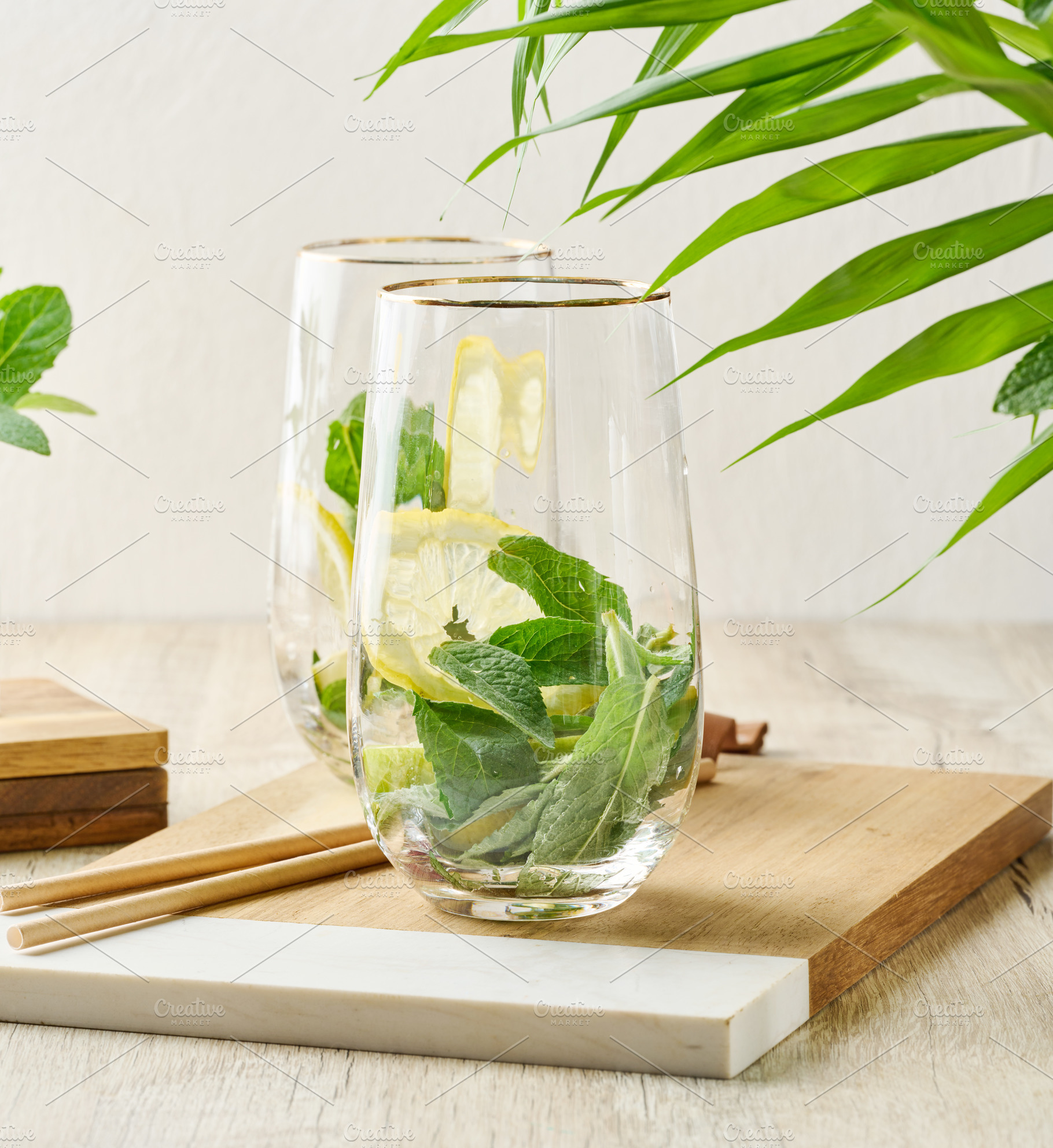 Preparing a refreshing drink. Two glasses filled with fresh lemo, a Food & Drink Photo by ndanko
