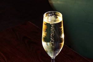 Sparkling champagne in a flute glass on a white napkin at a dim, a Photo by Studio ANNA