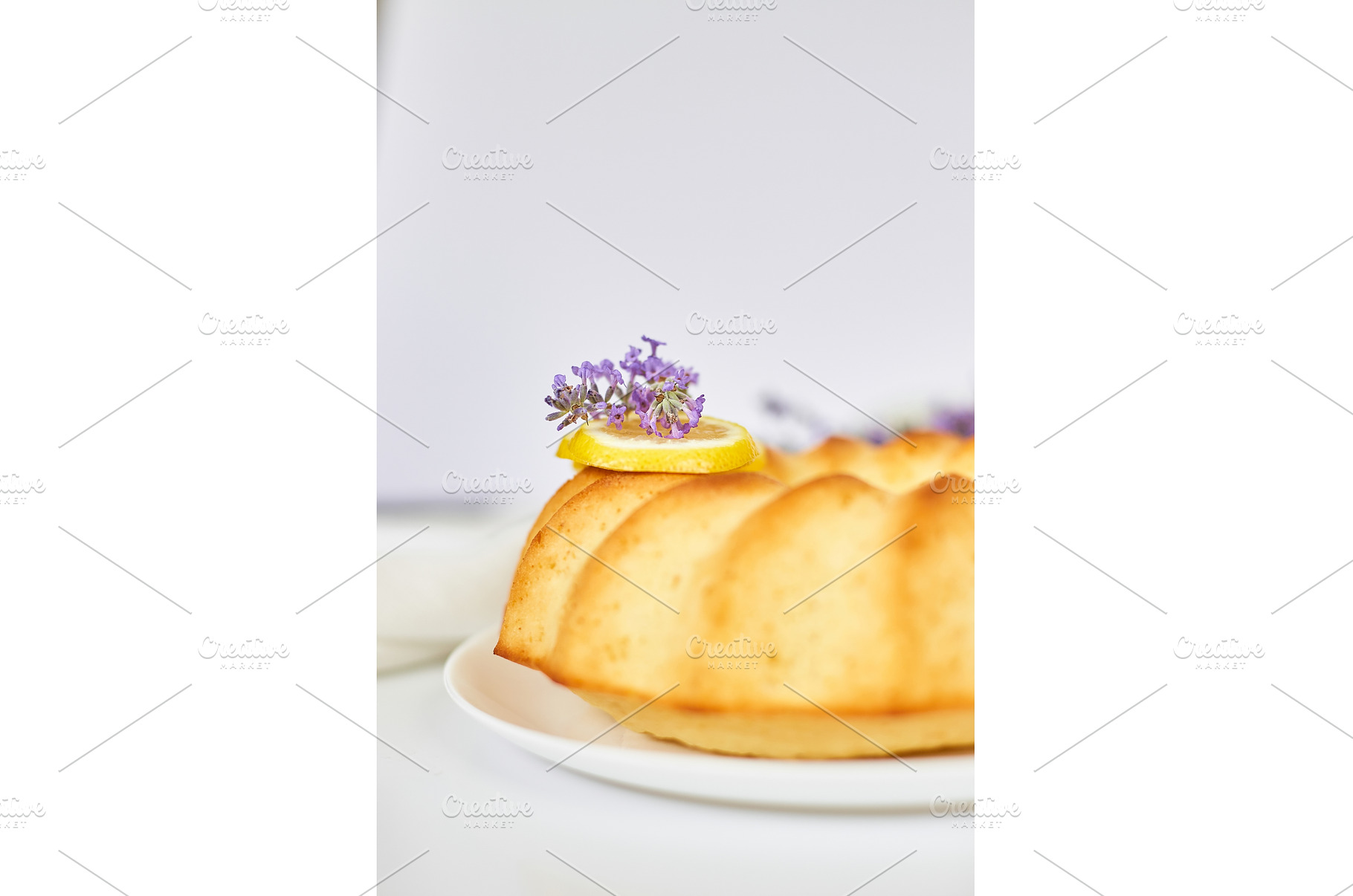 Round lemon cake on white table with, a Food & Drink Photo by IlliaBondarPhotography
