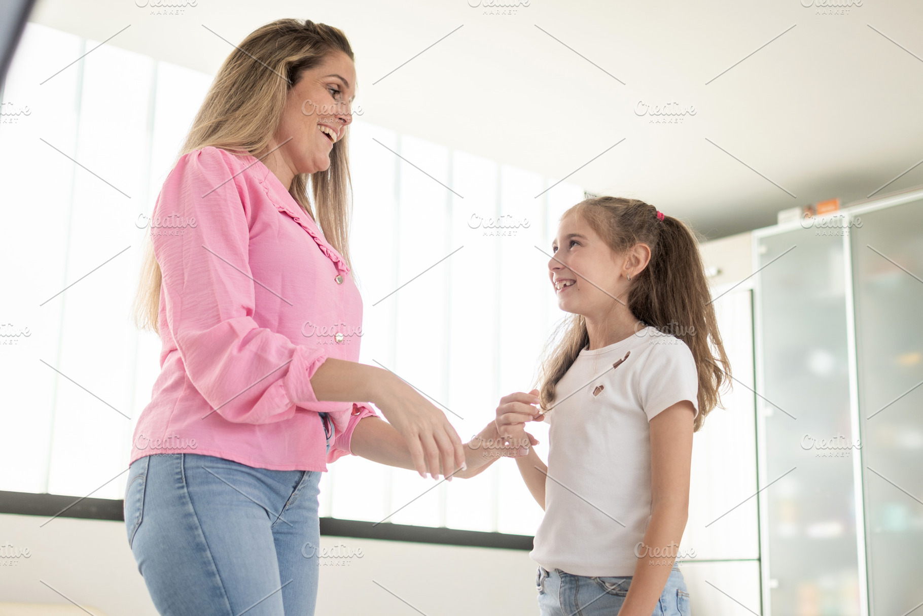 Happy mother and daughter smiling at each other in a bright modern home, a Person Photo by etorres69