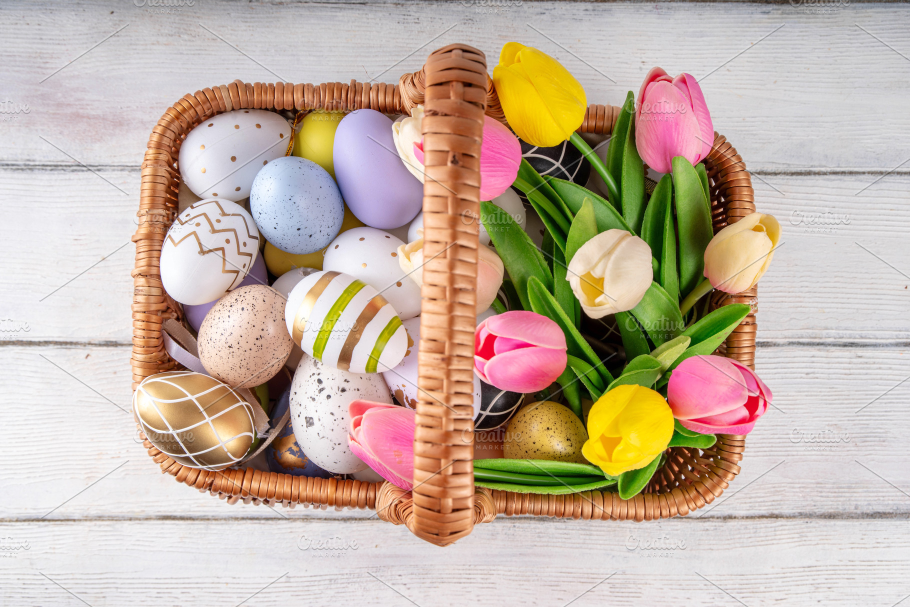 Easter eggs and tulips flowers in basket on wooden background, a Holiday Photo by Rimma