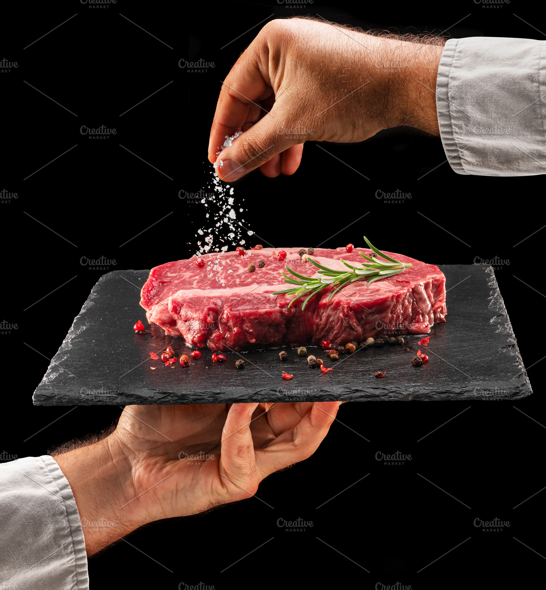 Chef is salting raw ribeye steak, a Food & Drink Photo by Volff