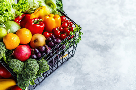 Shopping basket full of different grocery products on grey background, a Food & Drink Photo by AlyaAnd