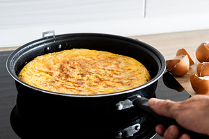 Spanish potato omelette cooking in frying pan, a Food & Drink Photo by etorres69