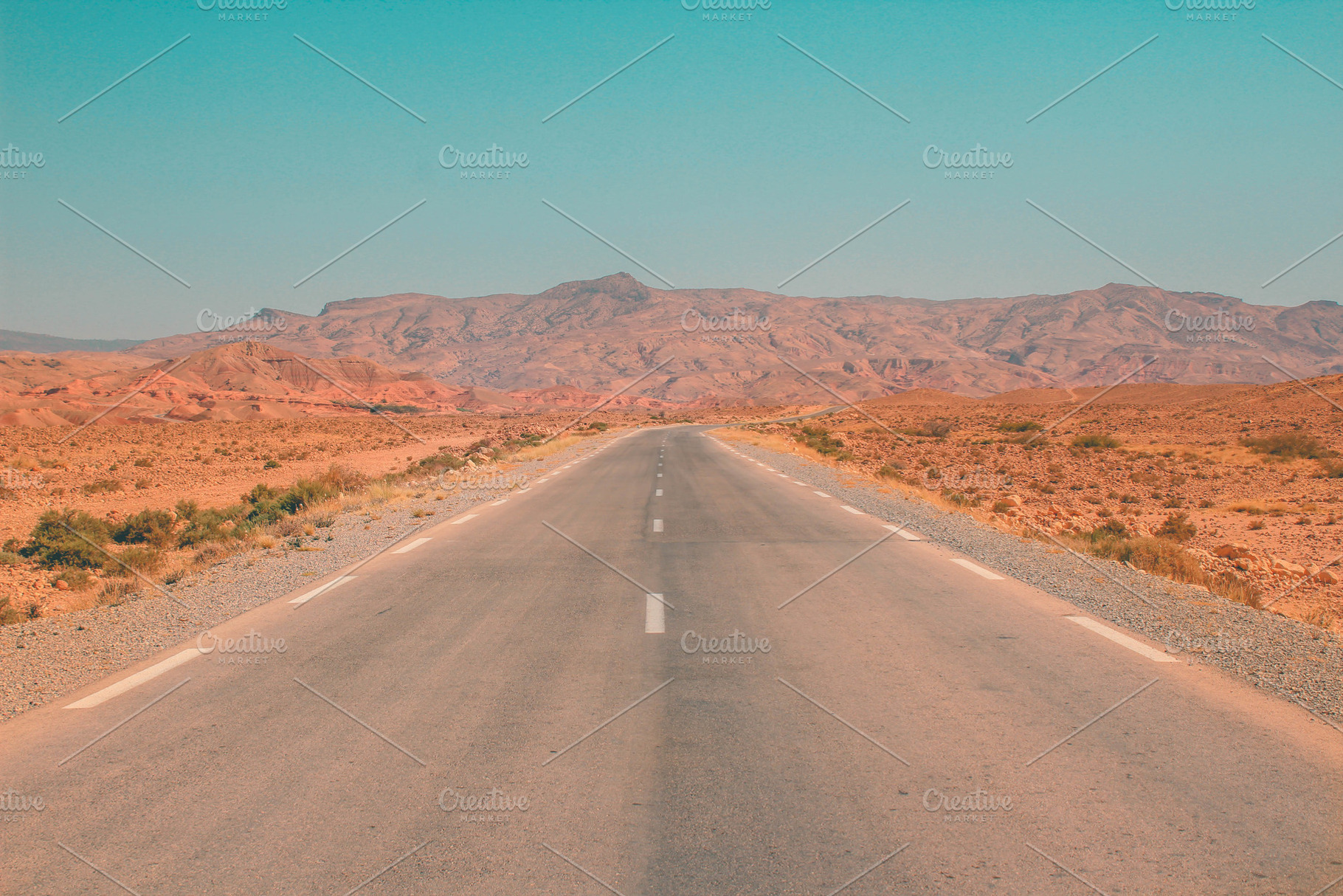 Road in the desert with mountains, a Nature Photo by The Pixels Factory