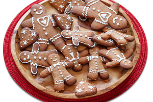 Wooden plate with gingerbread men on white background. File cont, a Food & Drink Photo by Volff