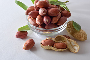 Peeled peanuts in bowl isolated on white table elevated view., a Food & Drink Photo by Davizro's Market