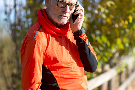Senior man in sportswear talking on phone outdoors