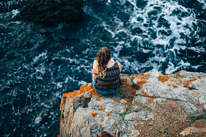 Girl sitting on clifs