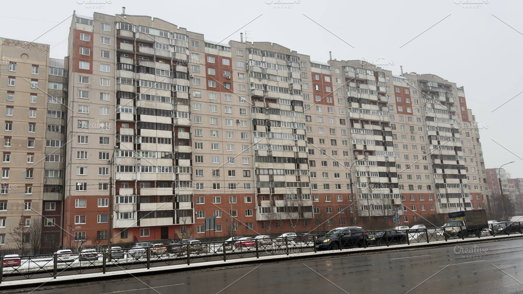 A row of modern apartment buildings in a snowy urban setting, with parked cars, an Industrial Photo by Textures & Backgrounds
