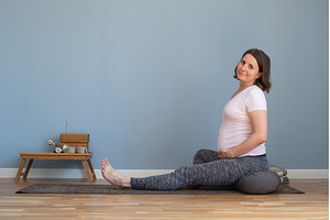 Pregnant woman sitting on yoga mat
