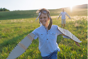 Child playing aviator in nature with, a Person Photo by HalfPoint