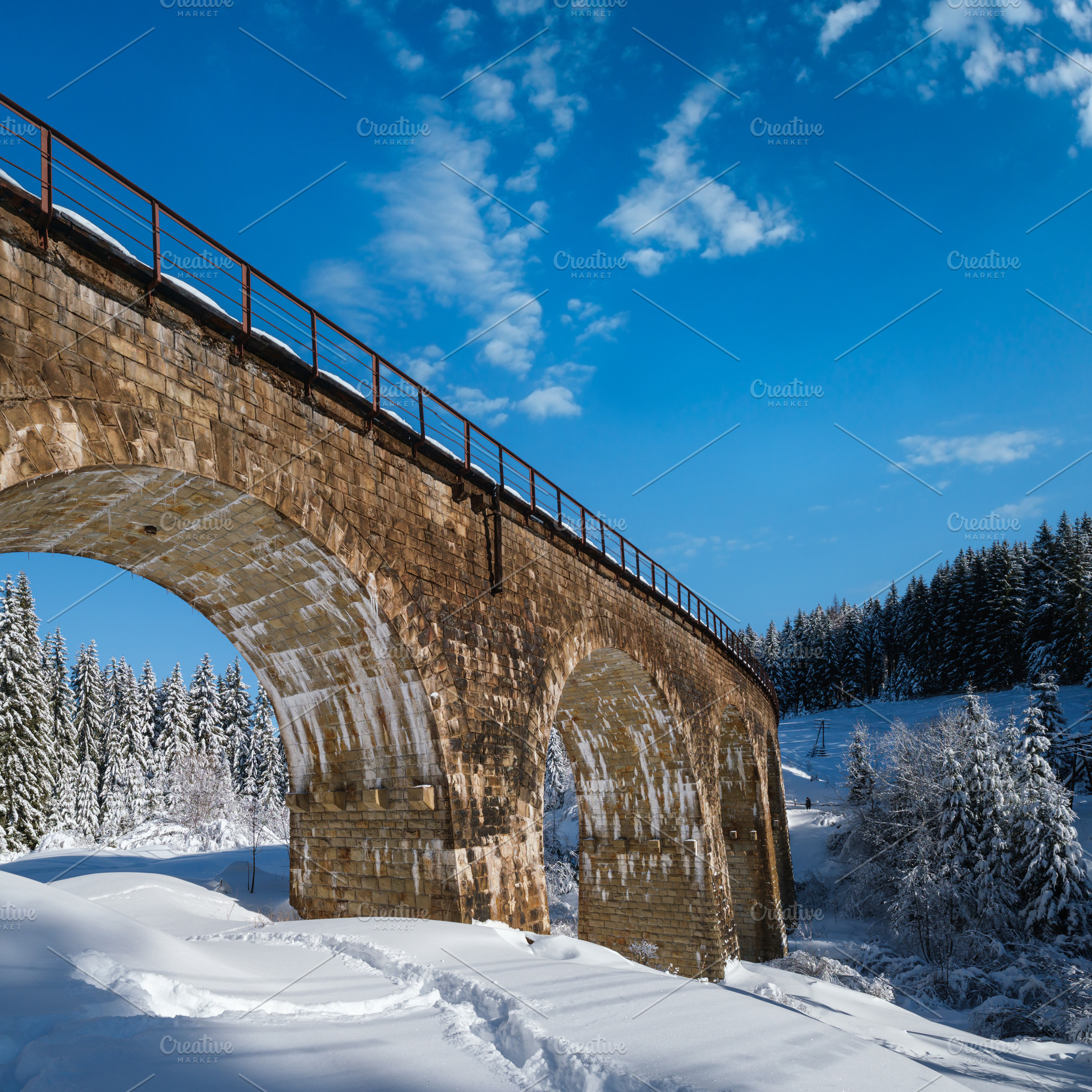 Stone viaduct (arch bridge) on railway through mountain snowy fi, a Nature Photo by YuriyB