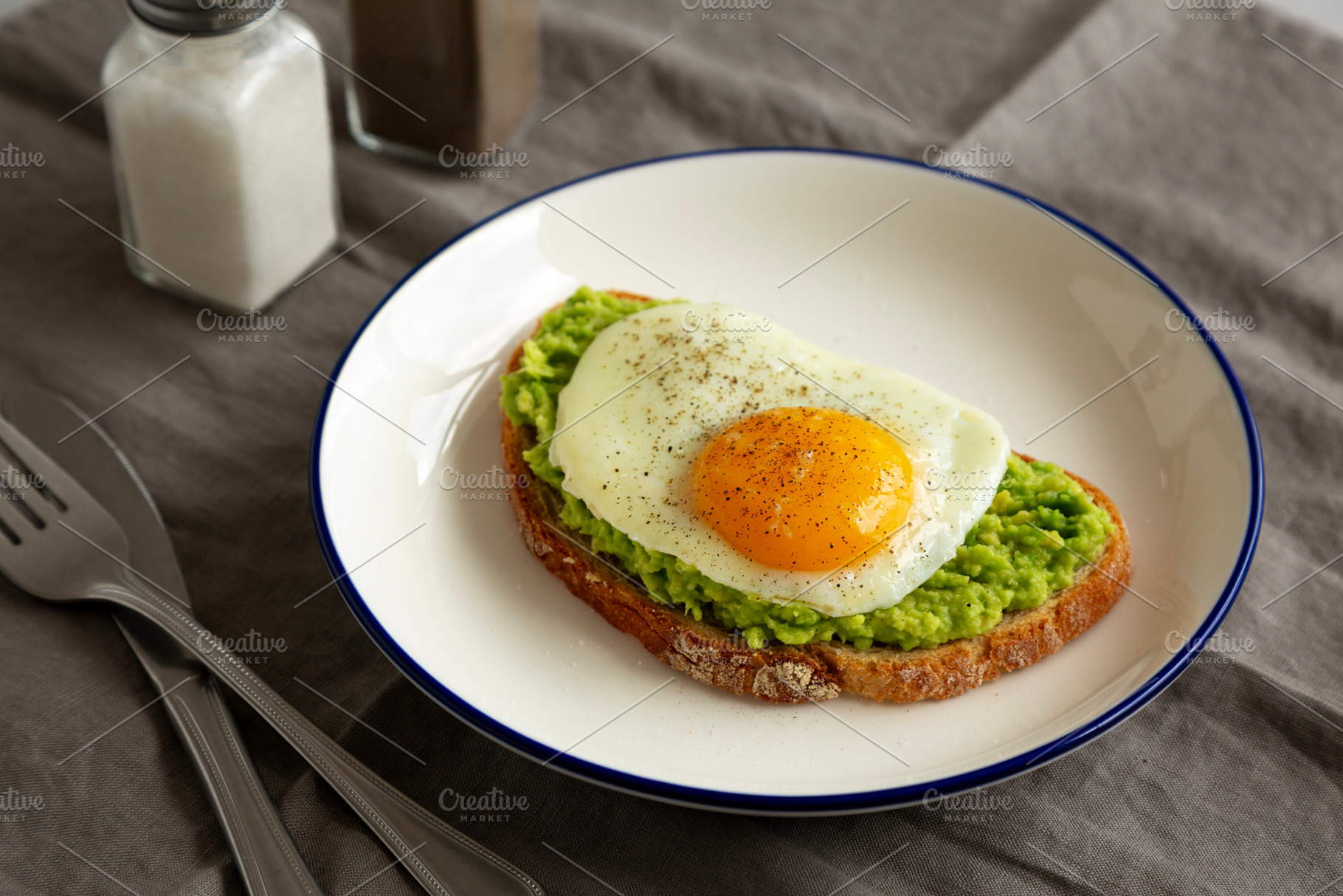 Homemade Avocado Toast with Egg on a Plate, side view. Close-up., a Food & Drink Photo by LiudmylaChuhunova