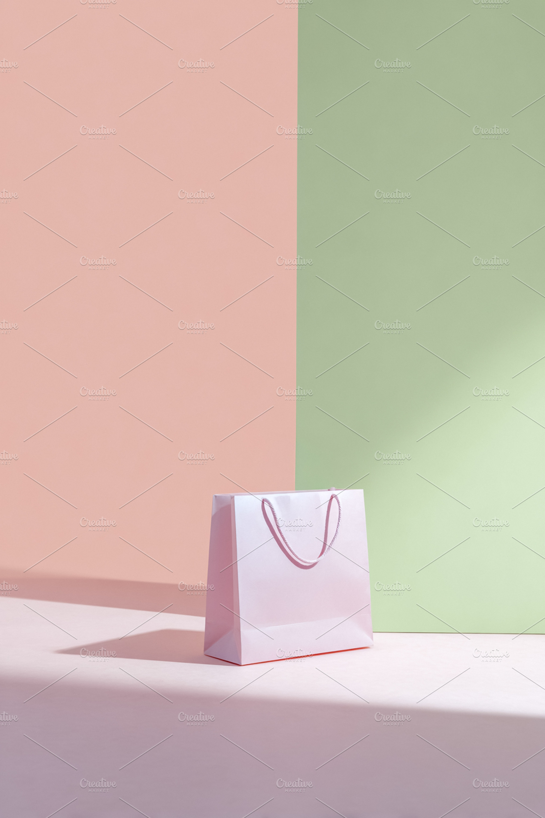 Pink shopping bag standing on a pink surface against a split pas, a Photo by Studio ANNA