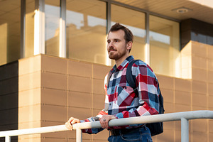 Young adult man standing by railing, a Person Photo by Elena Vagengeim