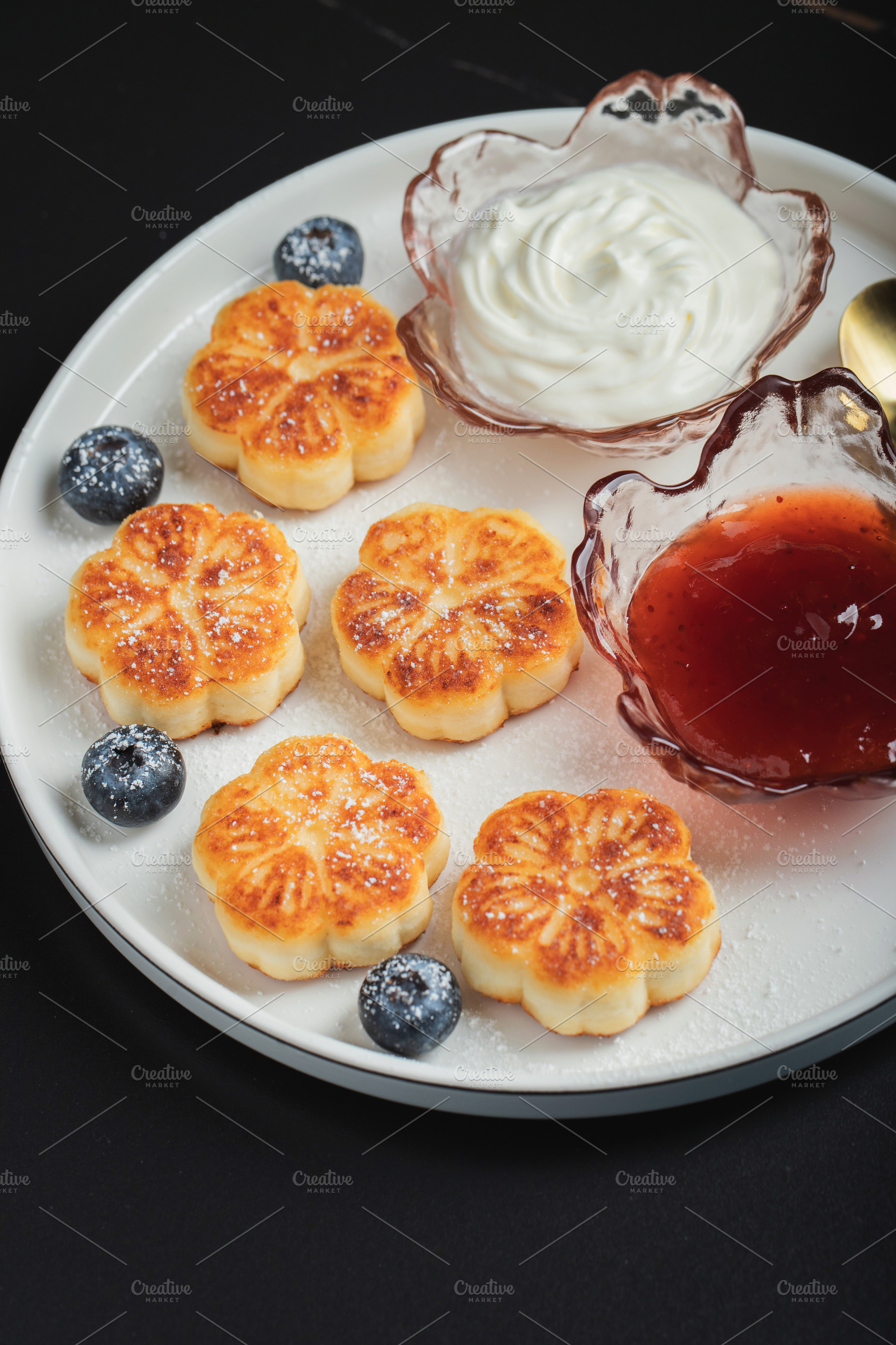 Cottage cheese pancakes, syrniki, curd fritters decorated with strawberry and r, a Food & Drink Photo by Budarinphoto