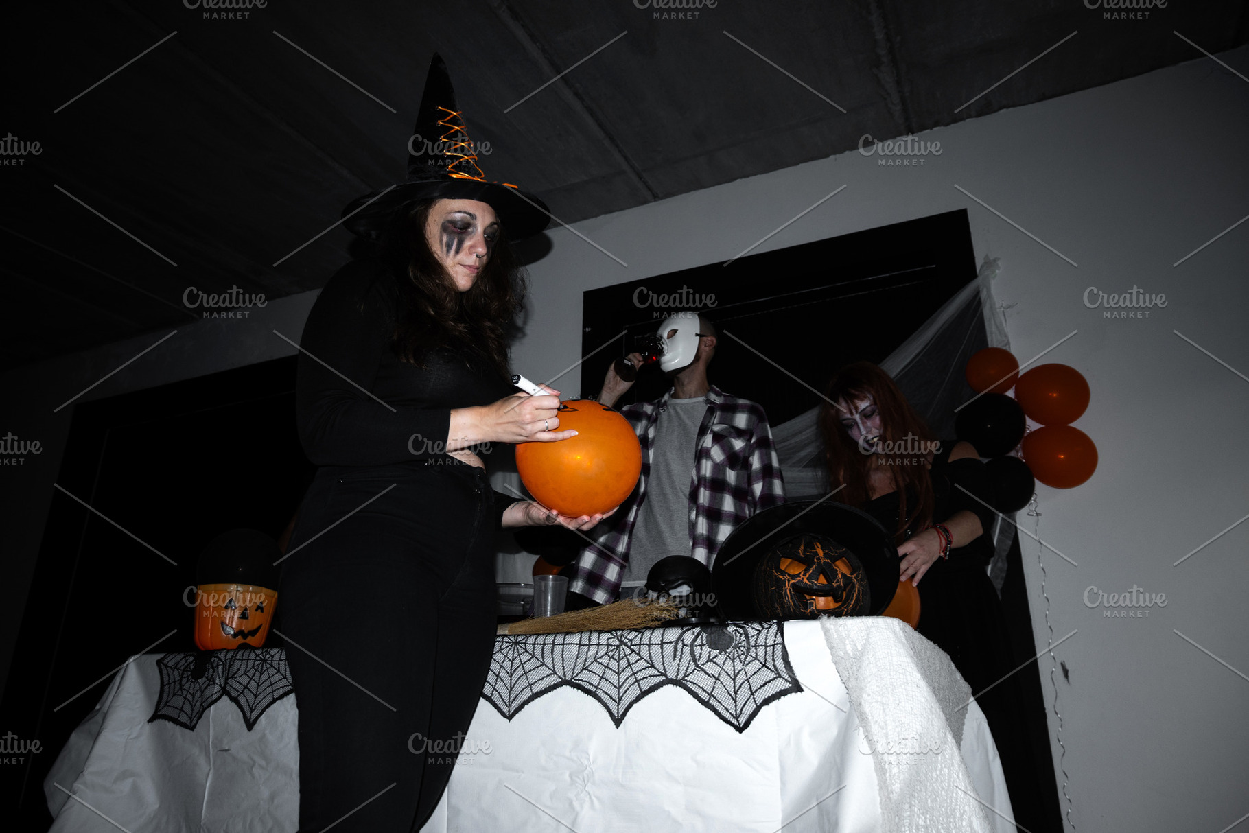 Friends decorating balloons during Halloween party, a Holiday Photo by etorres69