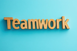 Word Teamwork by wooden letters on blue background, a Business Photo by AlyaAnd