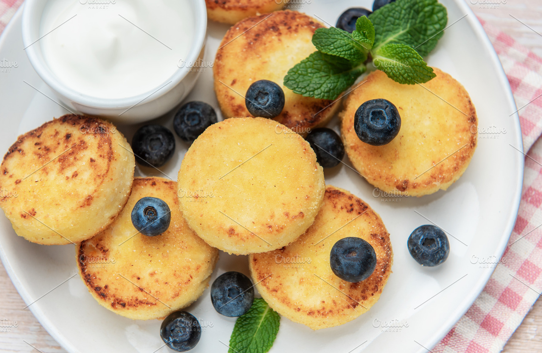 Syrniki cottage cheese pancakes served with blueberries and sour, a Food & Drink Photo by Olena Rudo
