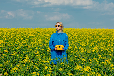 Ukrainian woman with yellow telephone in rapeseed field in sprin, a Person Photo by Masson Simon