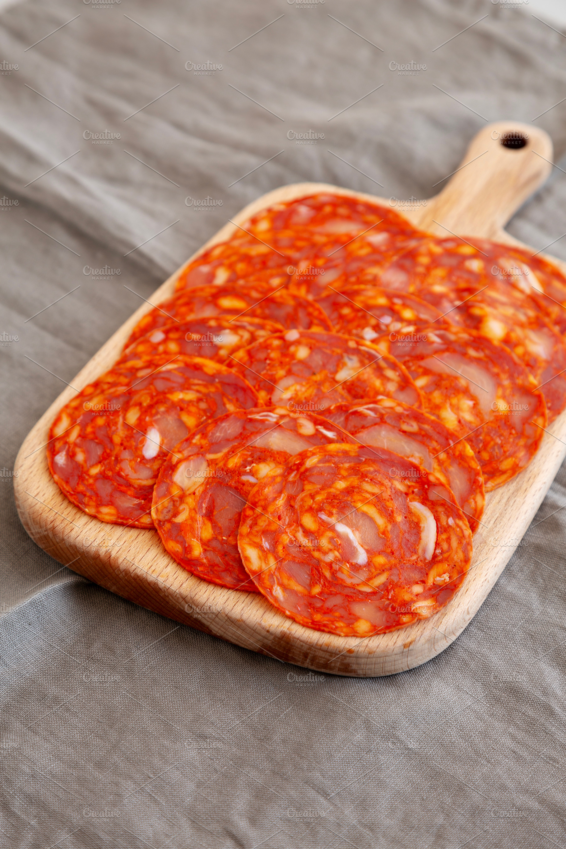 Cold Meat Chorizo Slices on a Wooden Board, side view., a Food & Drink Photo by LiudmylaChuhunova