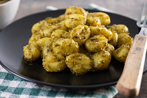 Gnocchi with pesto sauce served on black plate, a Food & Drink Photo by etorres69