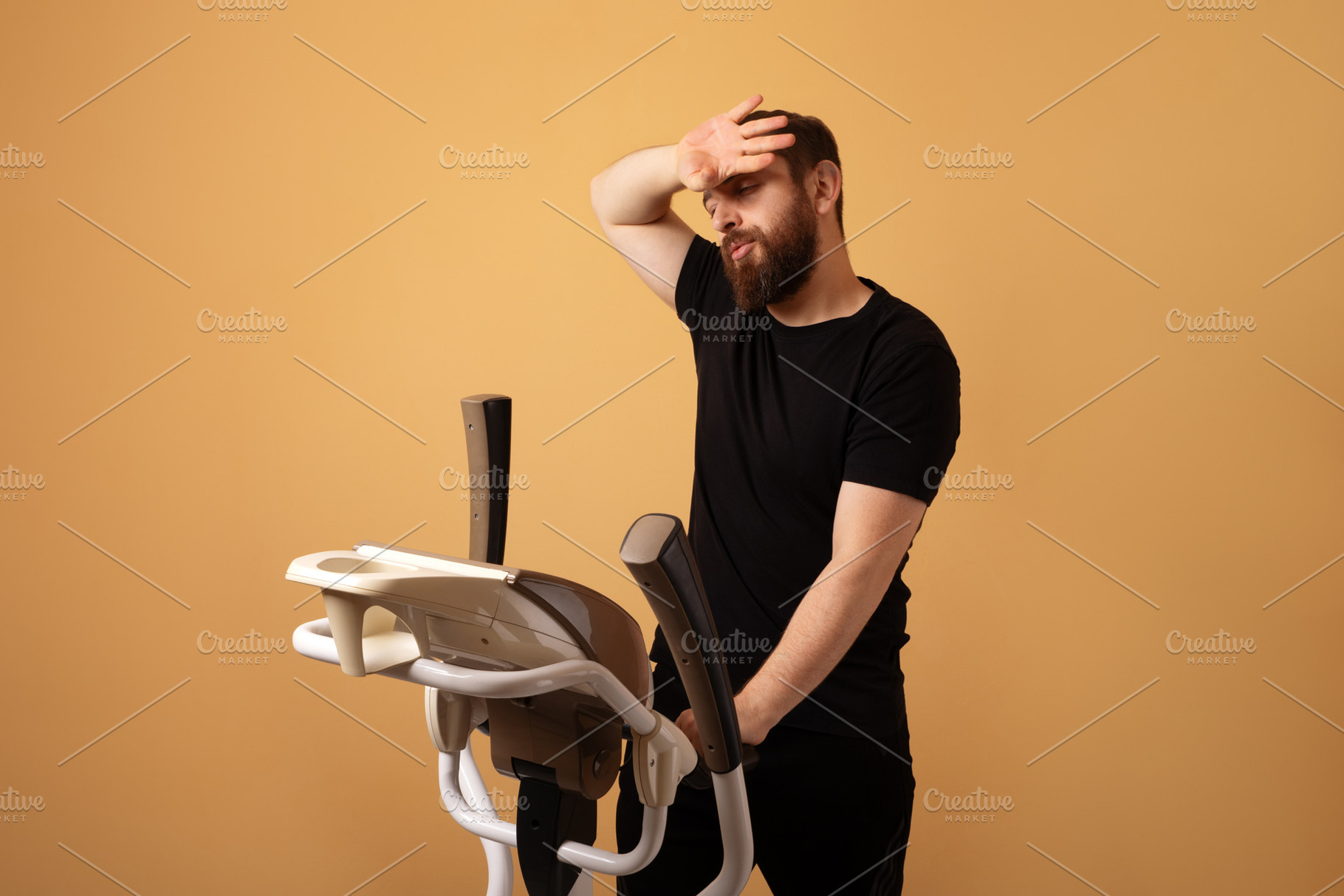 Bearded man in black sportswear looking fatigued while using a s, a Person Photo by Ales Munt