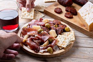 People sharing Spanish charcuterie board with ham, chorizo and cheese, a Food & Drink Photo by etorres69