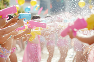 Children with Water toy spraying brightly colored stream in sunn, a Photo by Dvoevnore photos