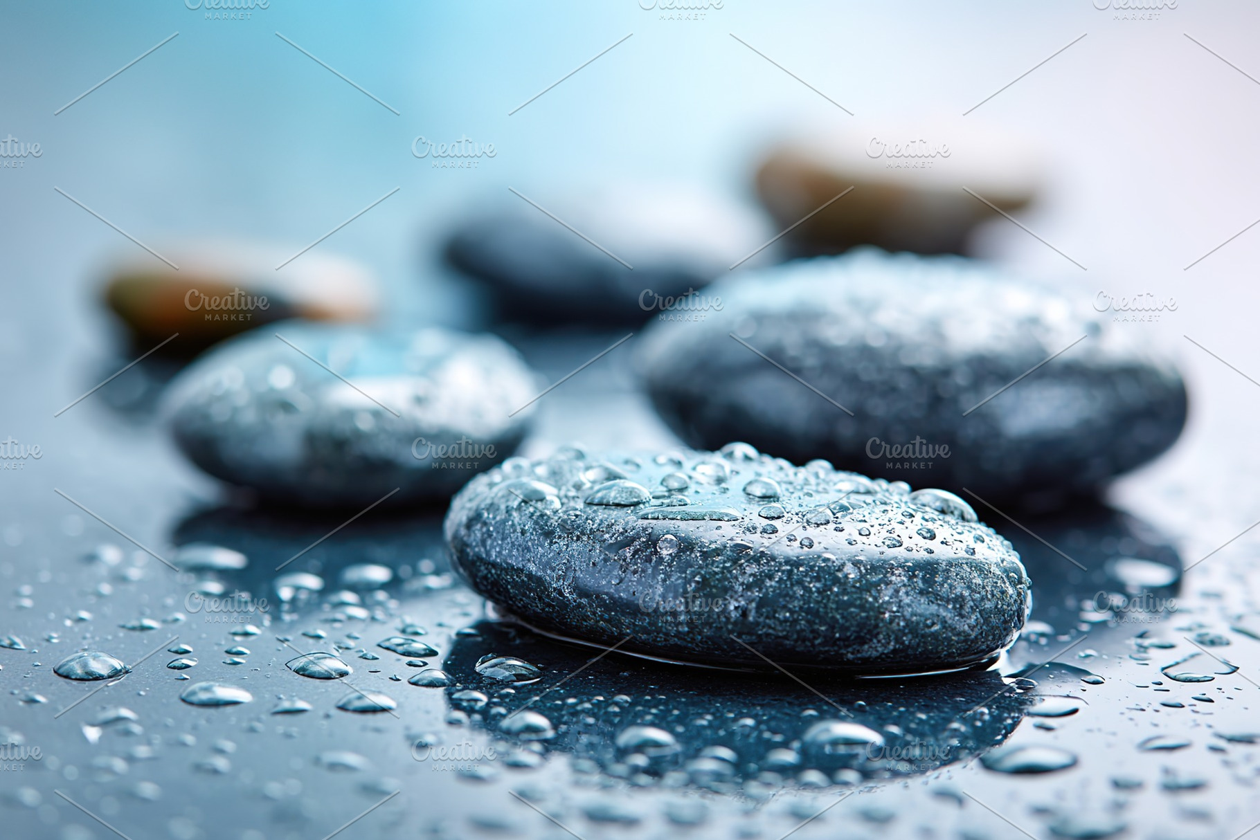 Wet stones glisten with droplets in a calming, serene setting after a gentle ra, a Photo by AlyaAnd