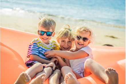 Children sit on an inflatable sofa, a Person Photo by Elizaveta Galitskaya