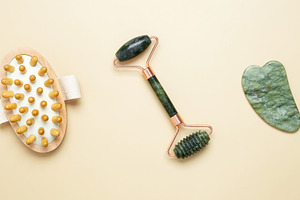 Skincare tools including marble roller, gua sha, and wooden brush arranged for, a Photo by matucha