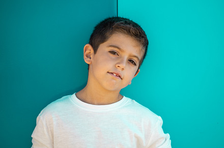 Pretty boy with a white t-shirt on a green blackground, a Person Photo by Cosca