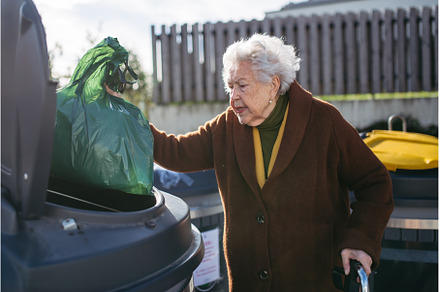 Elderly woman disposing of trash, an Architecture Photo by HalfPoint