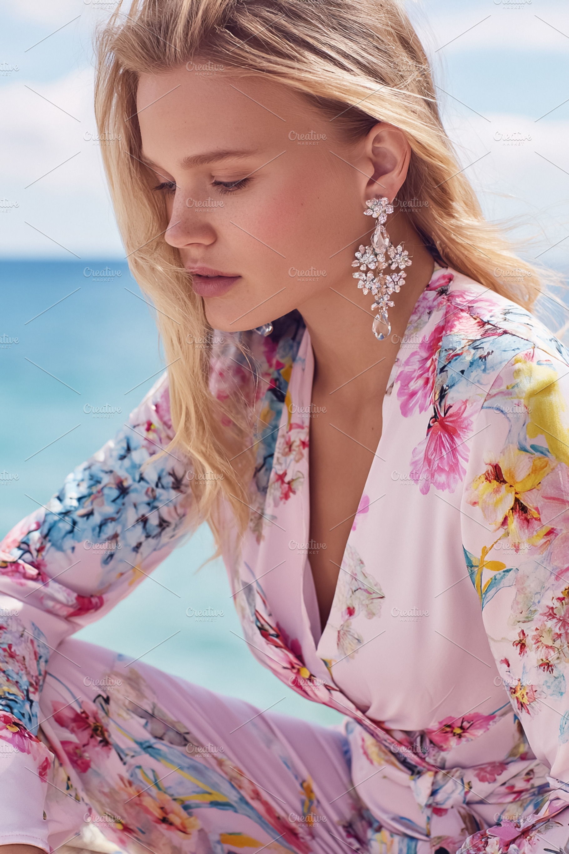 Elegant blonde woman posing at beach, showcasing her floral jump, a Photo by Studio ANNA