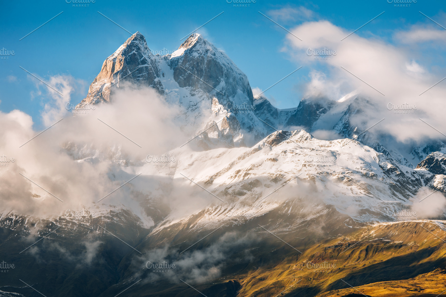 Snowy peak with clouds containing adventure, altitude, and autumn, a Nature Photo by David Khelashvili