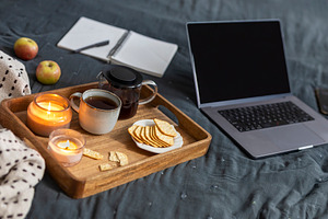 Cozy home workspace on a bed featuri, a Holiday Photo by Imaginarium