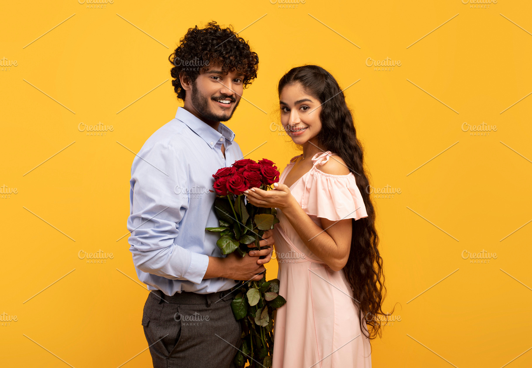 Lovers holiday. Romantic indian couple holding bouquet of flowers and looking a, a Photo by Prostock-Studio