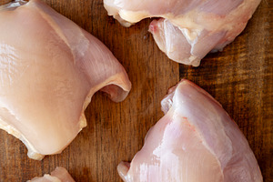 Raw Organic Boneless Skinless Chicken Thighs on a Wooden Board,, a Food & Drink Photo by LiudmylaChuhunova