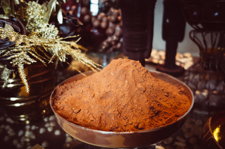 Cocoa powder in a metal cup on a rustic table, a Food & Drink Photo by GoodGoods