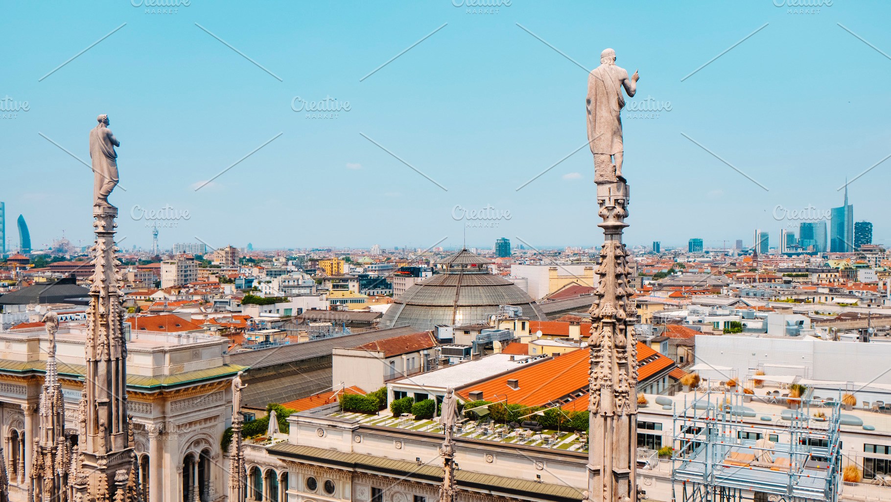 statues of the Duomo looking over Milan skyline, a Photo by Nito