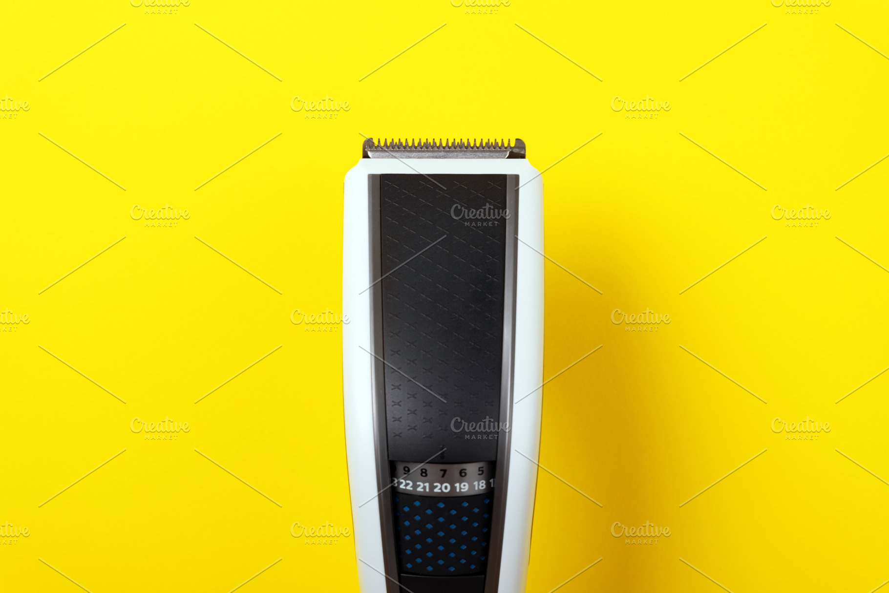 Close-up of a modern electric hair clipper on a vibrant yellow b, a Technology Photo by Ales Munt