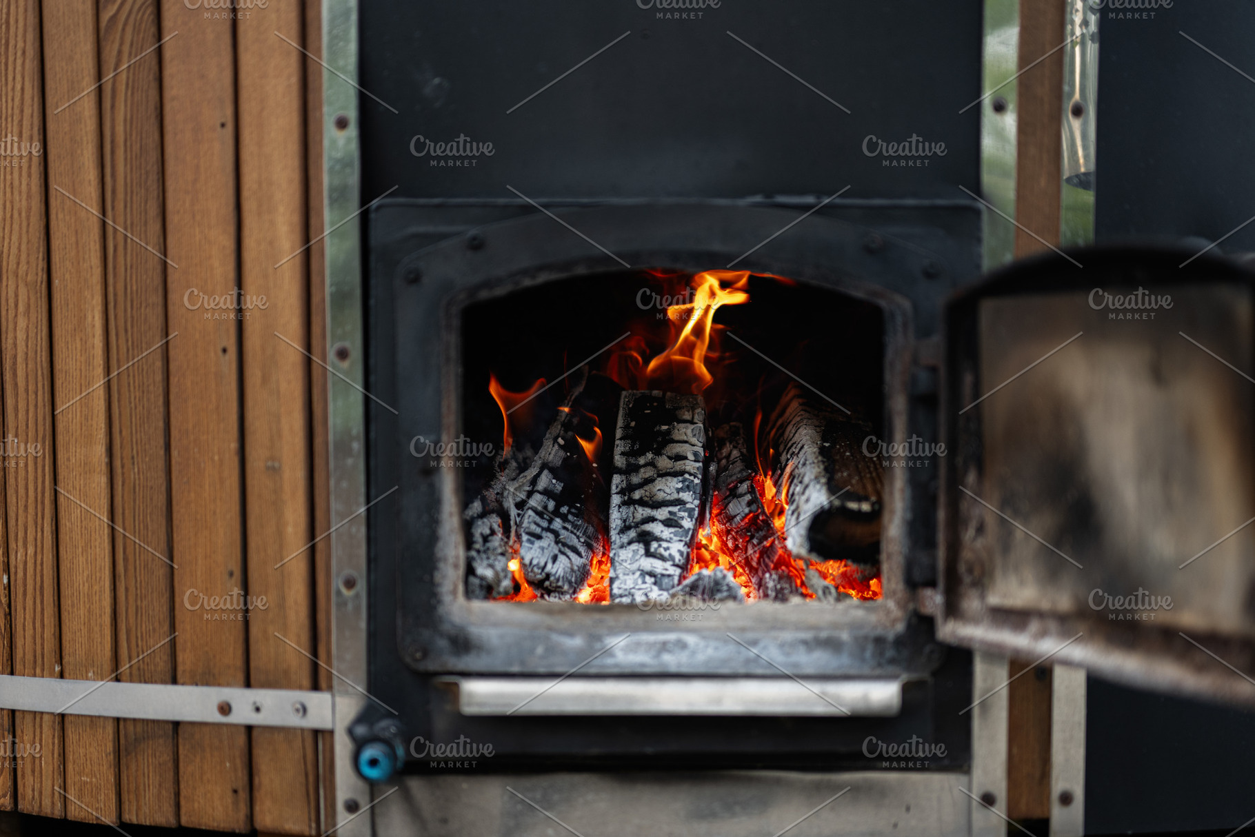 Burning Firewood in a Rustic Outdoor Stove for Warmth and Coziness, a Photo by AS photostudio