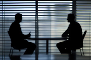 Two people engaged in conversation in a silhouetted setting by a window during, a Photo by AlyaAnd