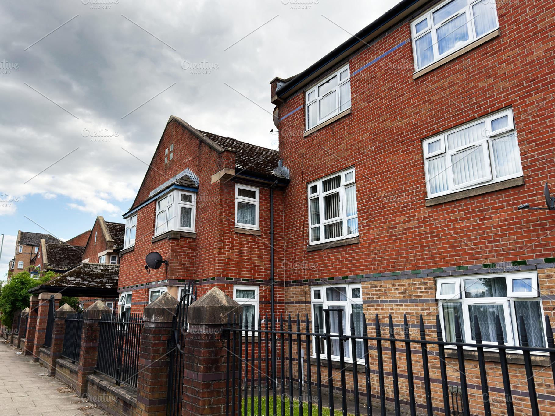 Residential red brick apartments with iron fence and sidewalk un, a Photo by AS photostudio