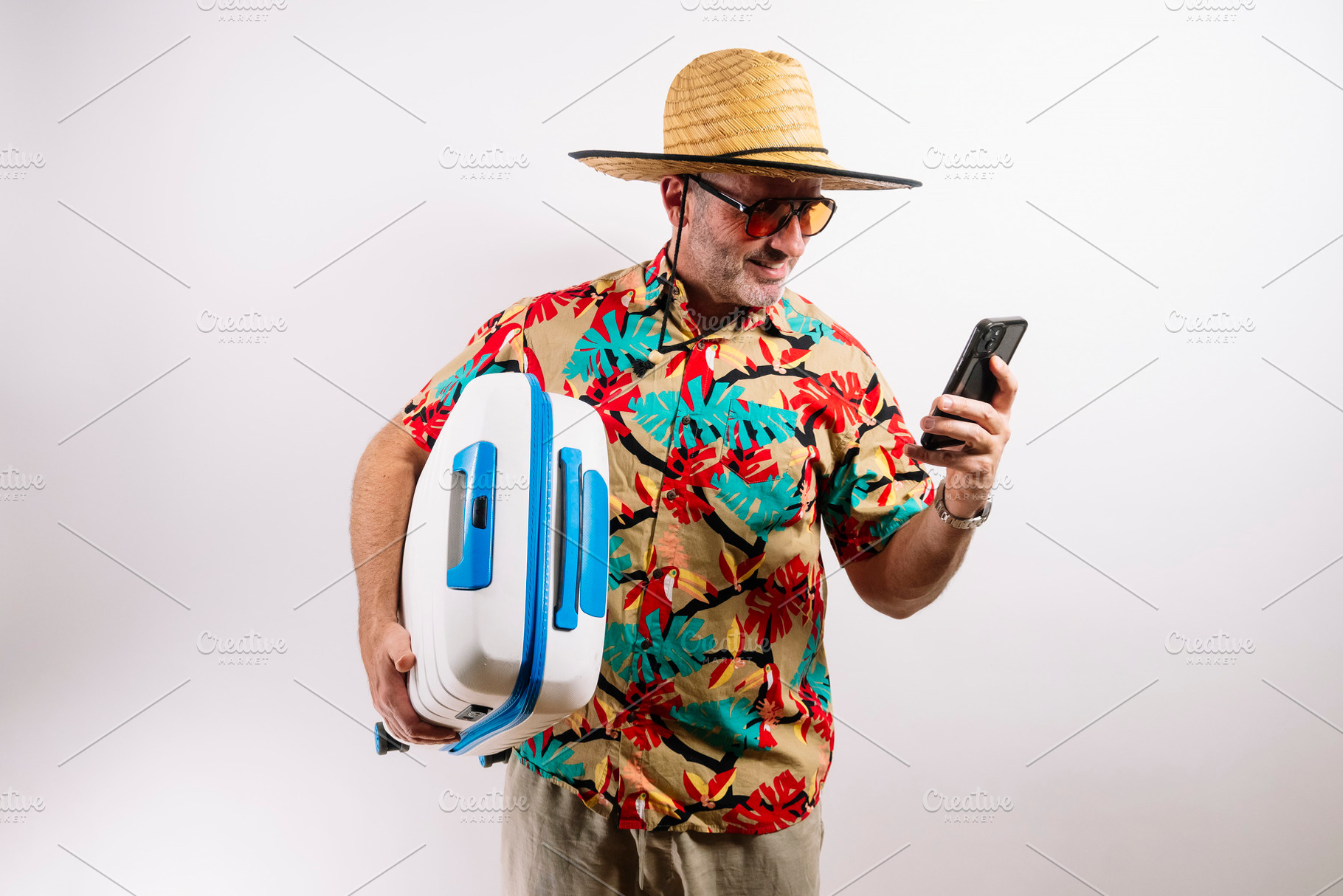 Traveler showing phone and holding blue suitcase, a Holiday Photo by karrastock