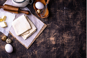 Raw puff pastry dough with baking, a Food & Drink Photo by Yulia Furman