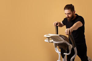 Bearded man in black sportswear using an elliptical machine on a, a Person Photo by Ales Munt