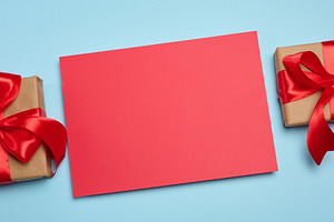 A red, blank rectangular sheet of paper between two craft-wrappe, a Holiday Photo by ndanko